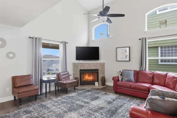a living room with furniture a flat screen tv and a fireplace