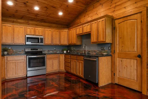 a kitchen with granite countertop wooden cabinets and a stove top oven