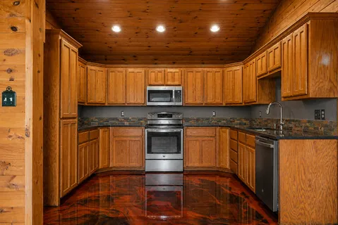 a kitchen with granite countertop a sink and stainless steel appliances