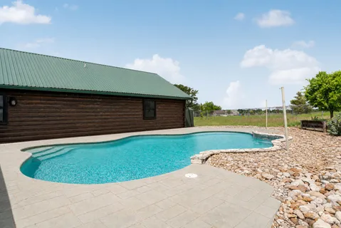 a view of a house with a swimming pool and a yard