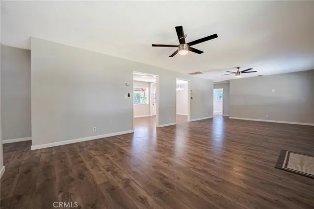 a view of a livingroom with wooden floor and ceiling fan