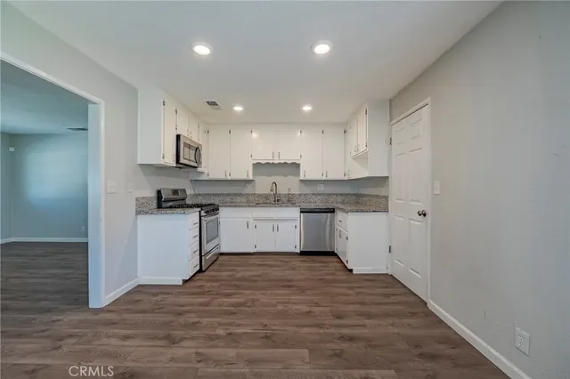 a kitchen with white cabinets stainless steel appliances and a sink