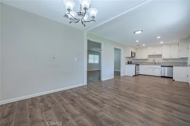 a view of kitchen with granite countertop cabinets and refrigerator