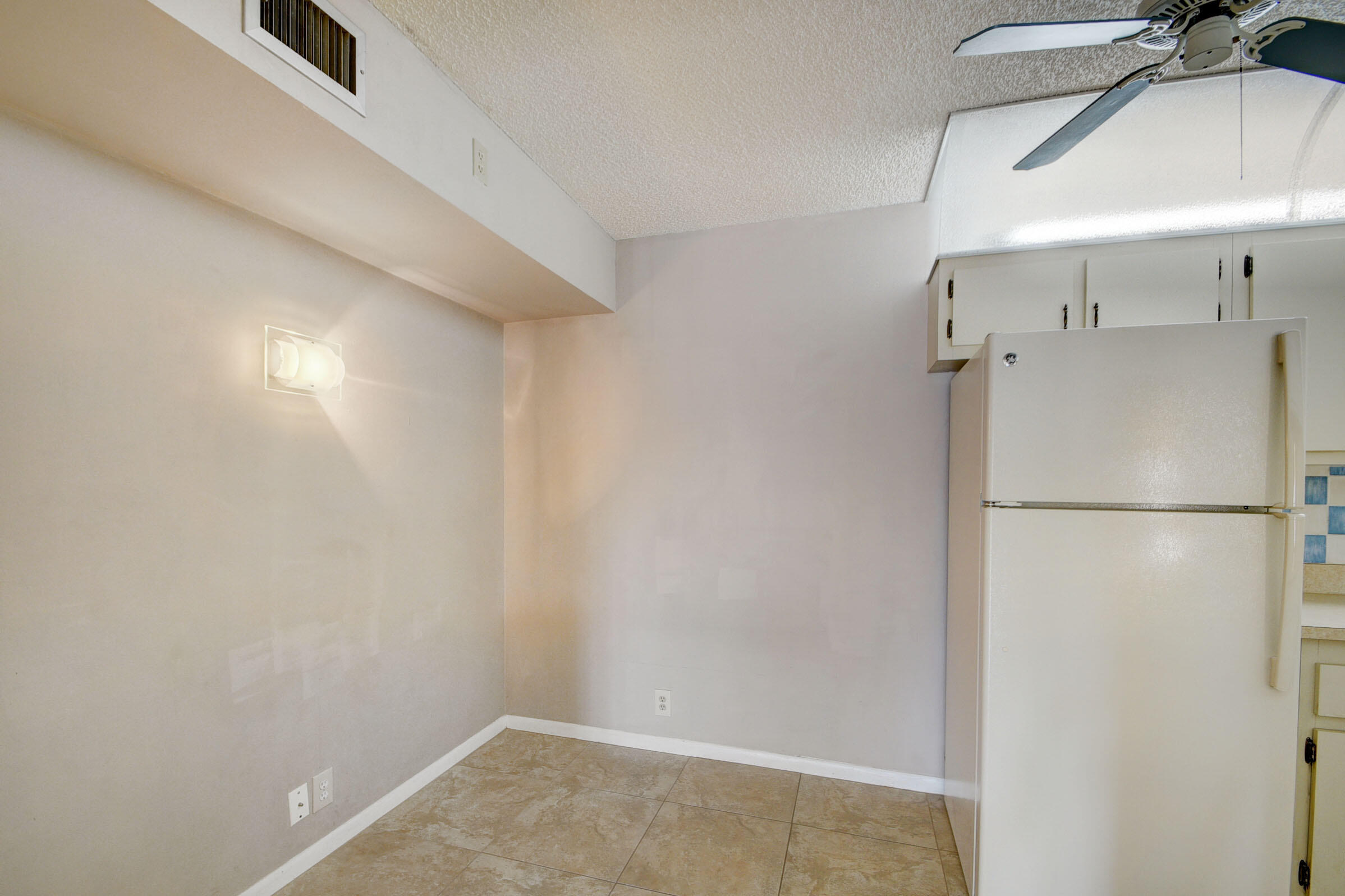 802 Sky Pine Way, Unit C2 Greenacres, FL 33415 - Photo 8 of 28 a view of a refrigerator in kitchen and an empty room