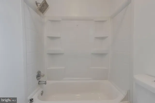 a bathroom with a toilet sink vanity and mirror