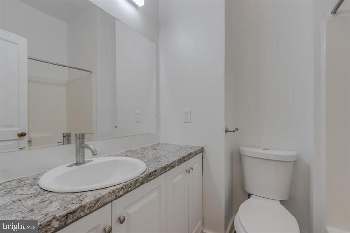 1113 North Calvert Street Baltimore, MD 21202 - Photo 25 of 25 a bathroom with a granite countertop toilet sink and mirror