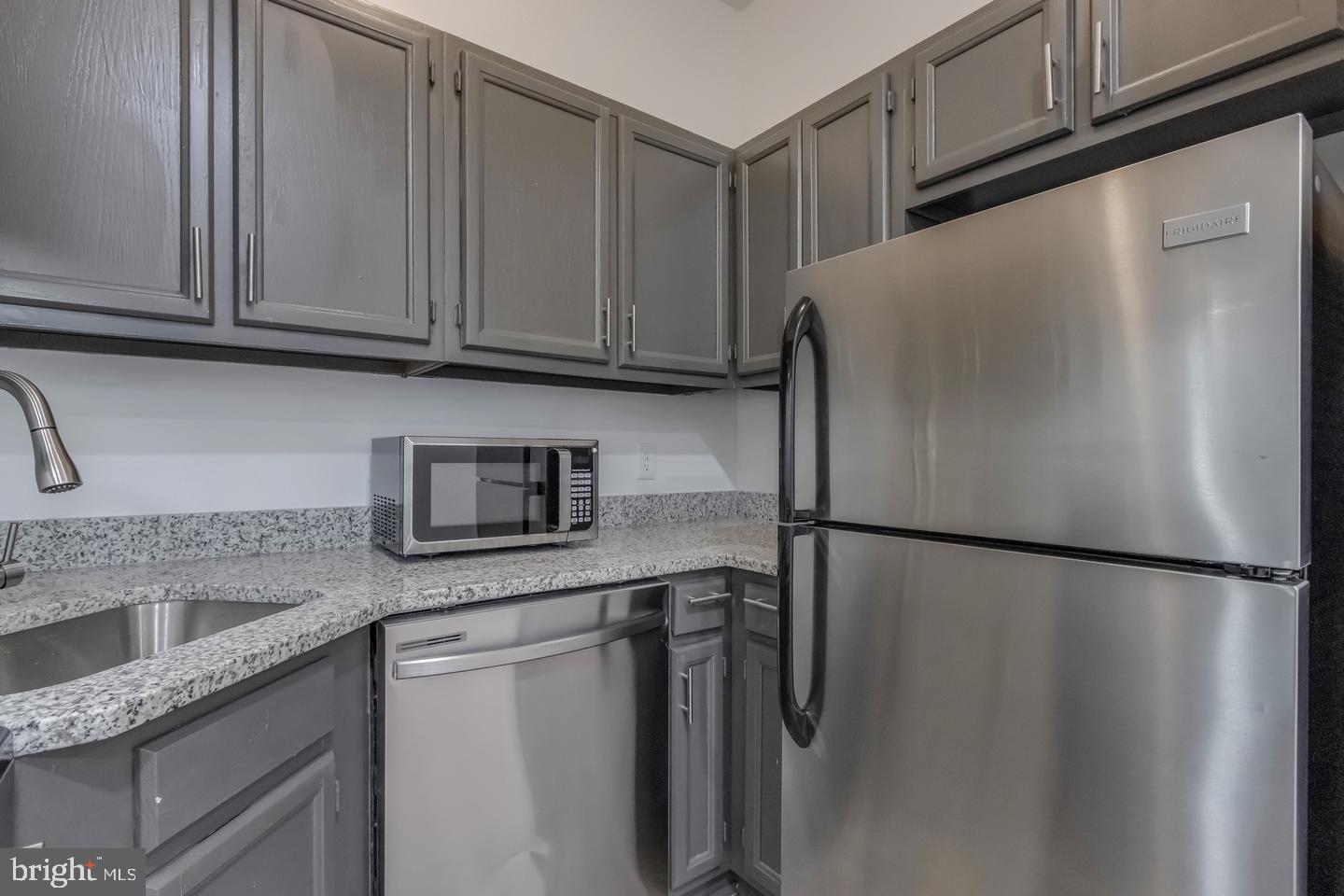 1113 North Calvert Street Baltimore, MD 21202 - Photo 6 of 25 a kitchen with stainless steel appliances granite countertop a refrigerator and a sink