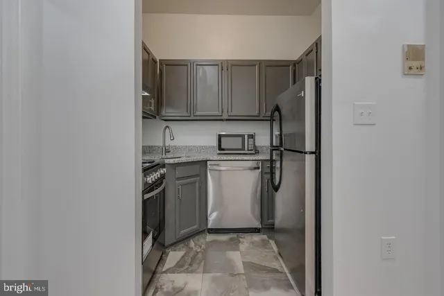 a view of a kitchen with a sink and a refrigerator