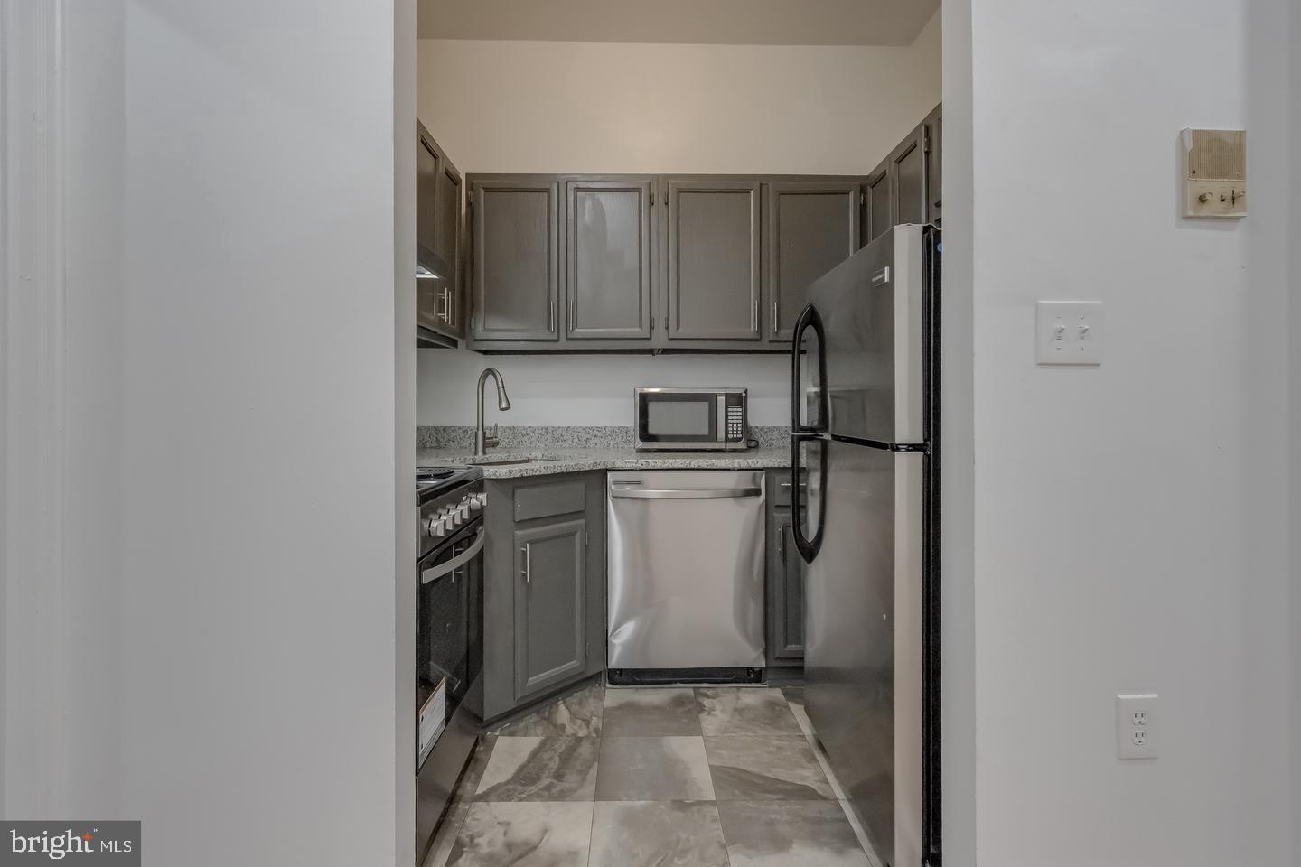 1113 North Calvert Street Baltimore, MD 21202 - Photo 8 of 25 a kitchen with a sink stove and refrigerator