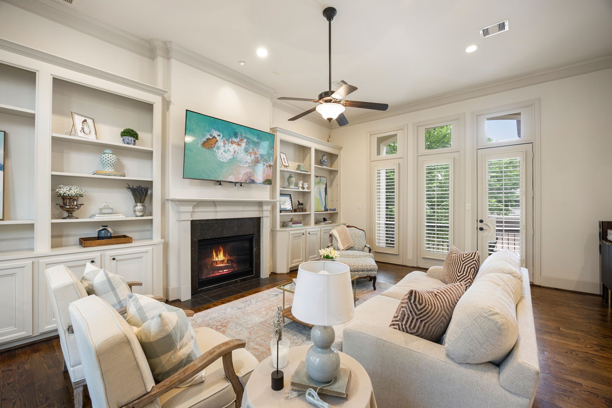 310 West Bell Street Houston, TX 77019 - Photo 12 of 44 The 2nd floor living room is inviting and features an elegant fireplace, built-in shelving, and beautiful hard wood floors. The French doors lead to an outdoor balcony with views of the lush courtyard below.