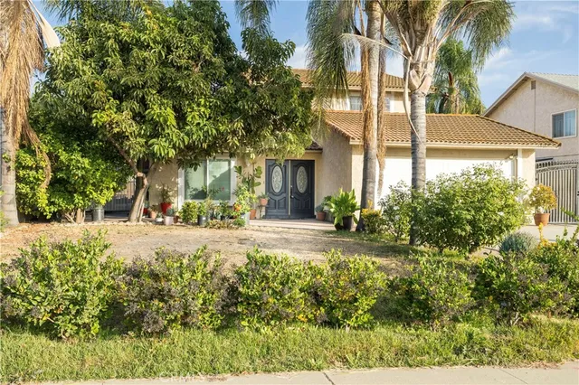 front view of a house with a yard and an trees