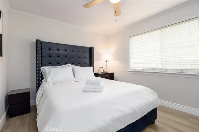 a large bed sitting in a bedroom next to a window and a chandelier