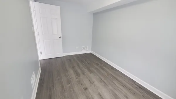 a view of a small space with wooden floor and a window