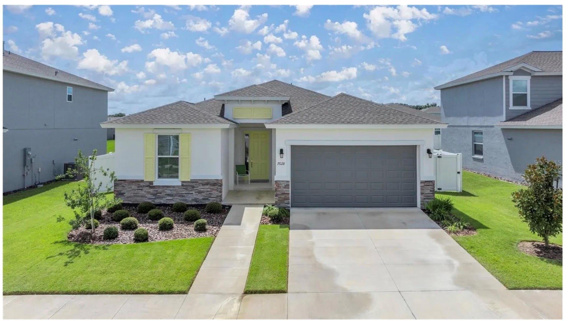 7628 Southwest 63rd Lane Road Ocala, FL 34474 - Photo 2 of 25 a front view of a house with a garden and yard