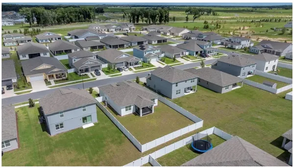 an aerial view of residential houses with outdoor space and parking