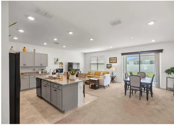 a living room with stainless steel appliances kitchen island granite countertop furniture a sink a counter top and stainless steel appliances