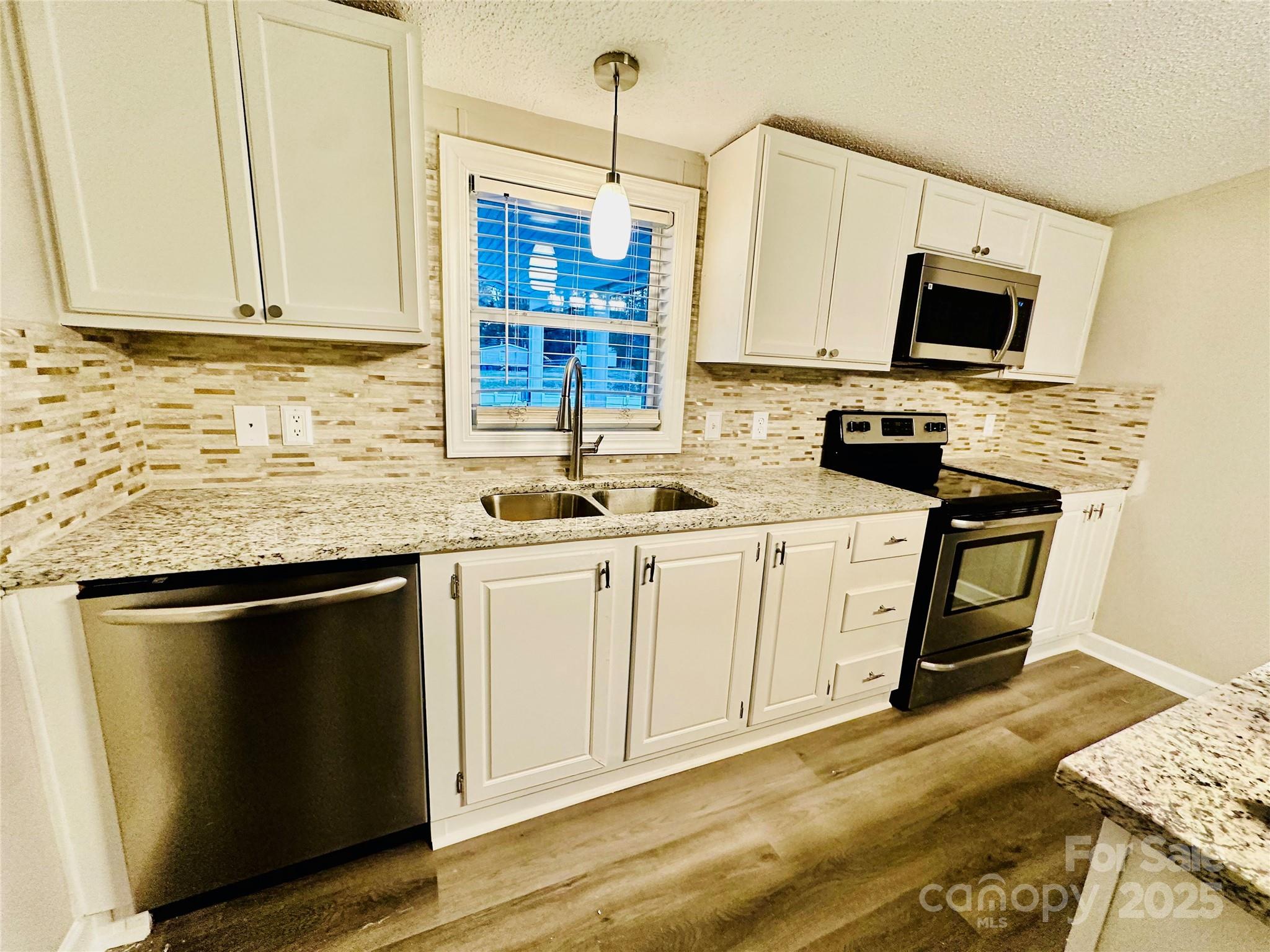 980 Olde Creek Trail Concord, NC 28025 - Photo 11 of 26 a kitchen with stainless steel appliances granite countertop a sink stove and microwave