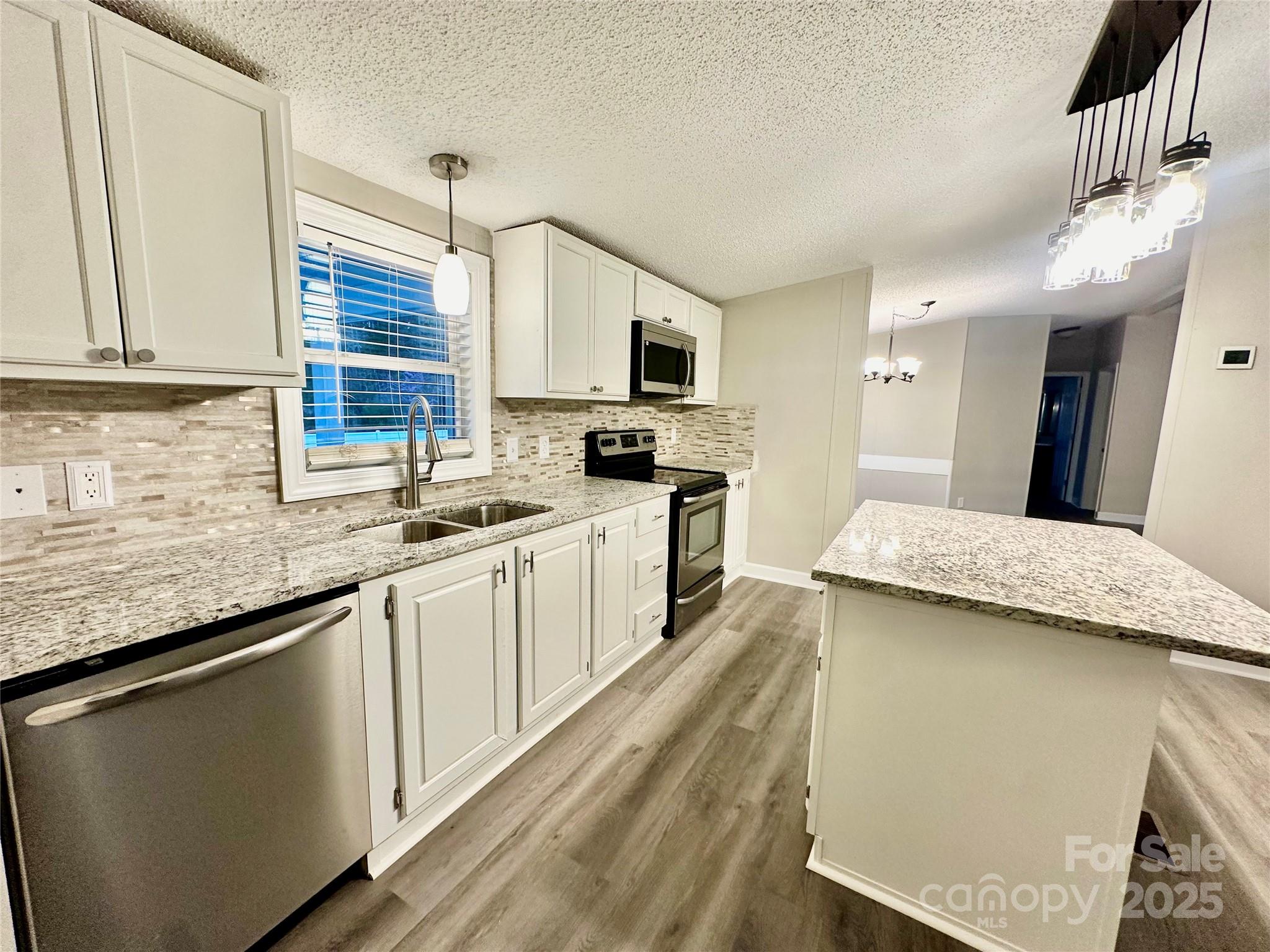 980 Olde Creek Trail Concord, NC 28025 - Photo 12 of 26 a kitchen with granite countertop a sink a counter top space and cabinets