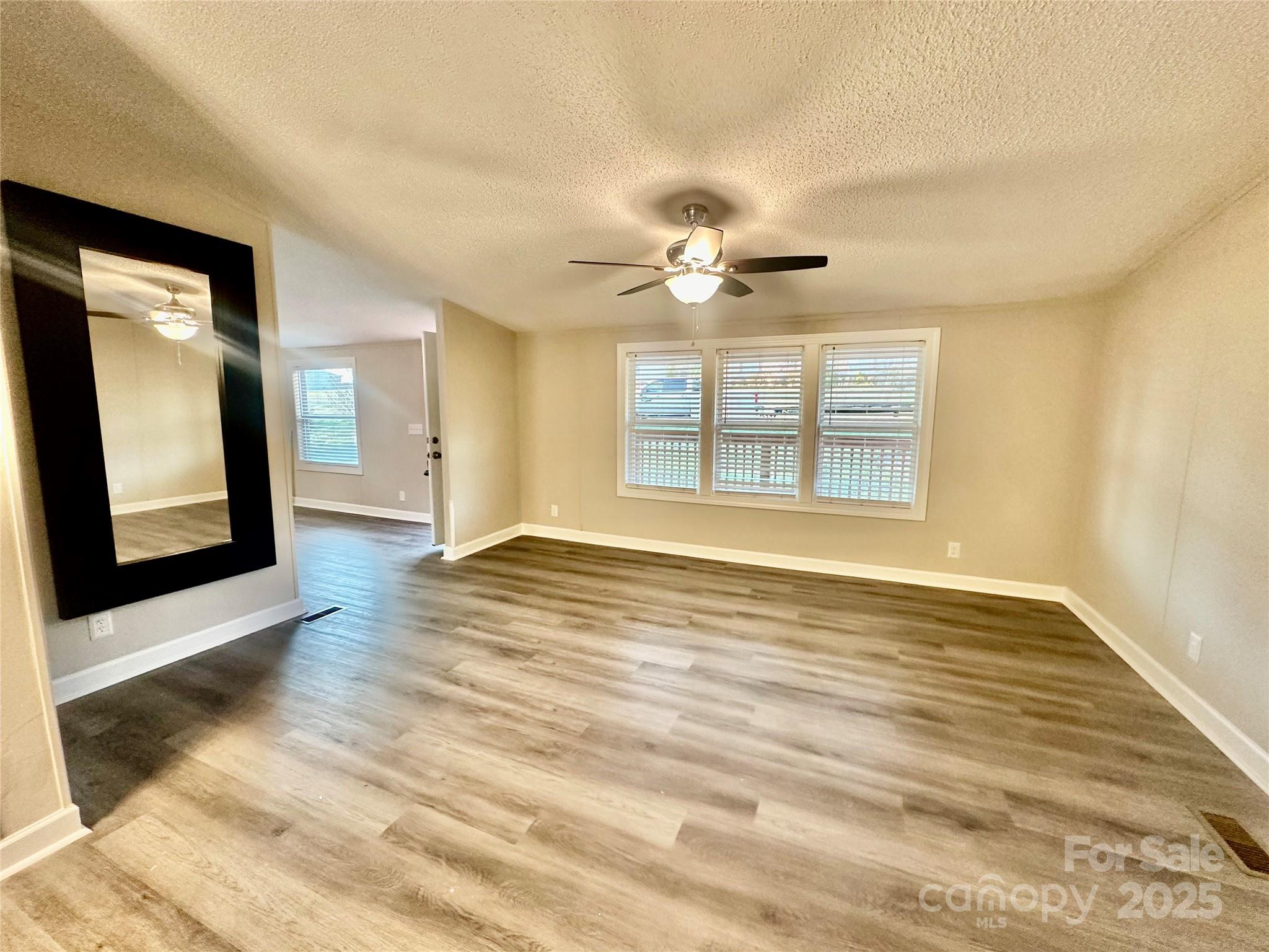 980 Olde Creek Trail Concord, NC 28025 - Photo 4 of 26 a view of an empty room with a window and wooden floor