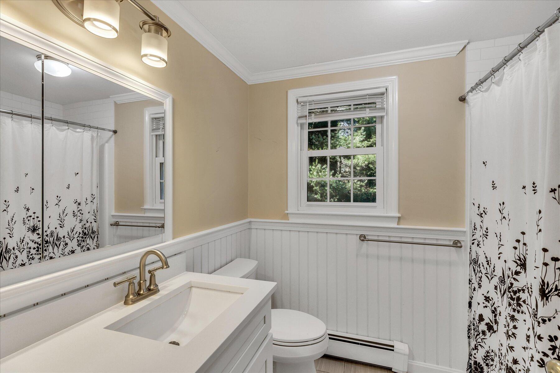 53 Deer Ridge Road Mashpee, MA 02649 - Photo 32 of 50 a bathroom with a sink a toilet and a window
