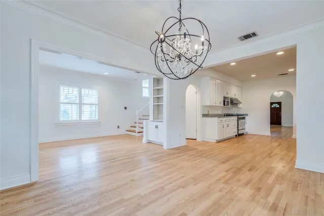 a view of a room with wooden floor fridge and a window