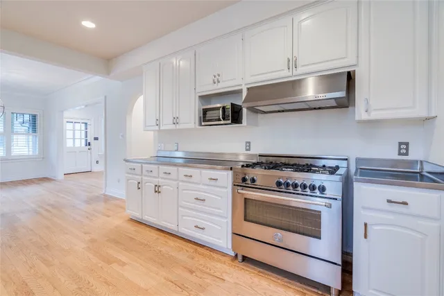 a kitchen with granite countertop white cabinets and stainless steel appliances