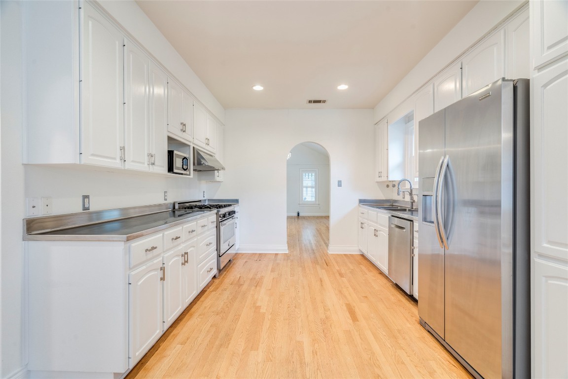 512 East 49th Street, Unit A Austin, TX 78751 - Photo 8 of 31 a large kitchen with kitchen island a counter top space a sink stainless steel appliances and cabinets