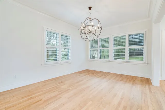a view of big room with wooden floor and windows
