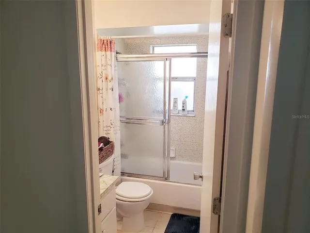 a bathroom with a granite countertop toilet a sink and a mirror