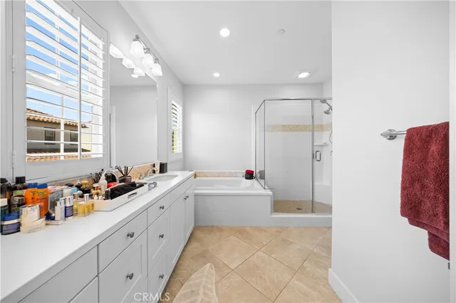 a bathroom with a tub sink mirror and vanity