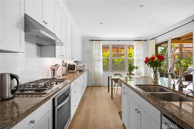 a kitchen with granite countertop a sink stove and cabinets