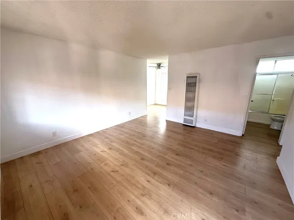 an empty room with wooden floor and mirror