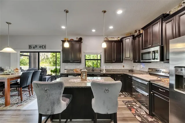 a kitchen with stainless steel appliances granite countertop a stove refrigerator and a sink
