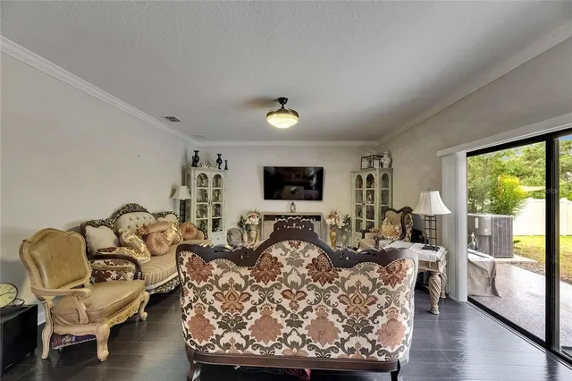 a view of a hallway with wooden floor staircase and a living room