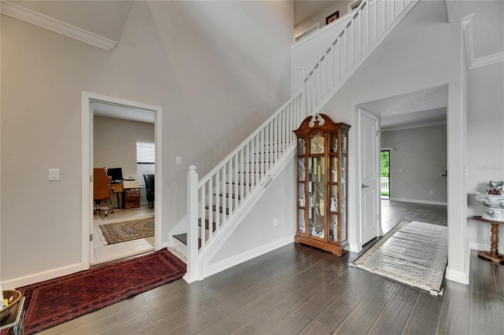 5057 Ivory Stone Drive Wimauma, FL 33598 - Photo 18 of 46 a view of a hallway with wooden floor staircase and a living room