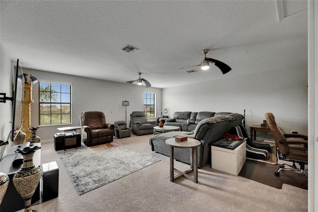 5057 Ivory Stone Drive Wimauma, FL 33598 - Photo 24 of 46 a living room with furniture gym equipment and a large window