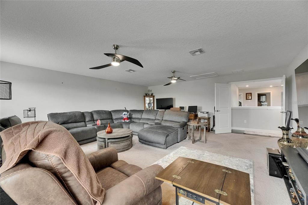 5057 Ivory Stone Drive Wimauma, FL 33598 - Photo 25 of 46 a living room with furniture and a chandelier