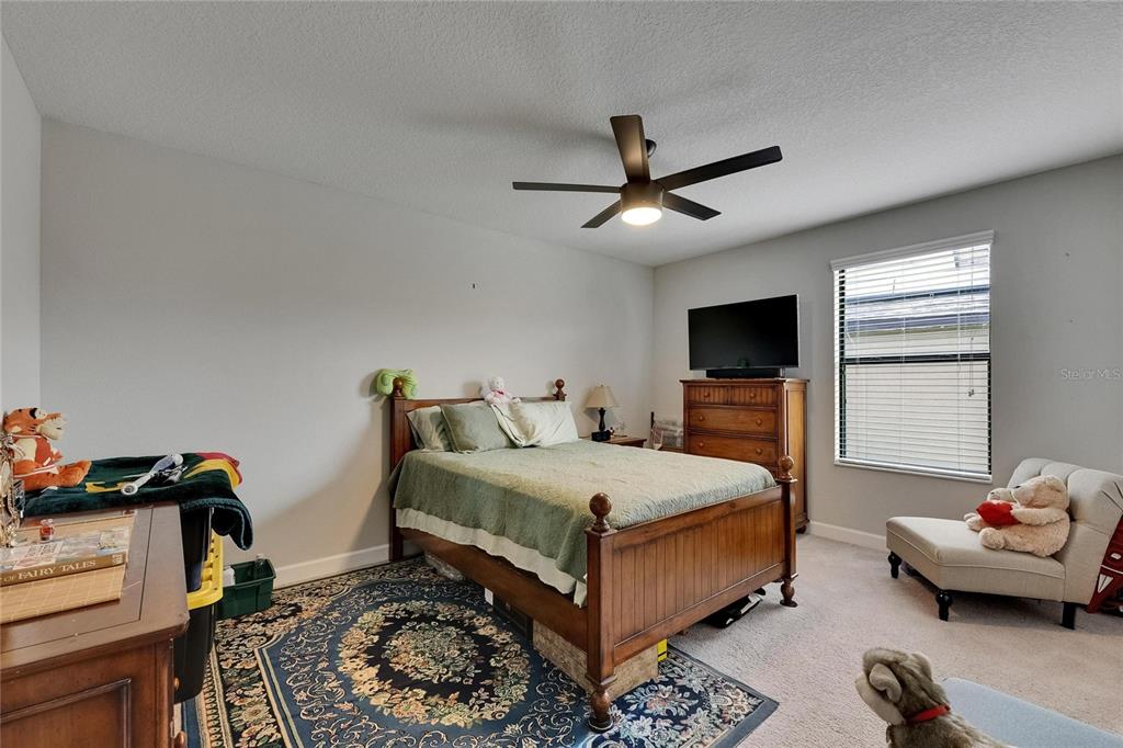 5057 Ivory Stone Drive Wimauma, FL 33598 - Photo 35 of 46 a bedroom with a bed and a tv