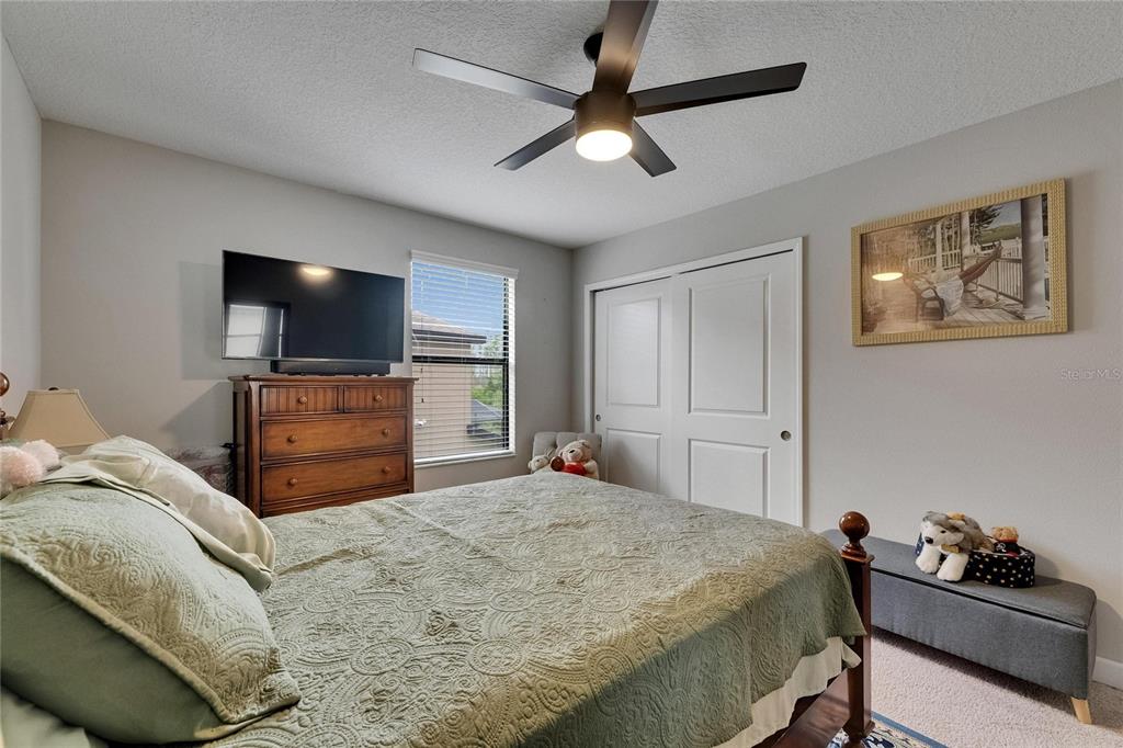 5057 Ivory Stone Drive Wimauma, FL 33598 - Photo 36 of 46 a bedroom with a bed and a flat screen tv