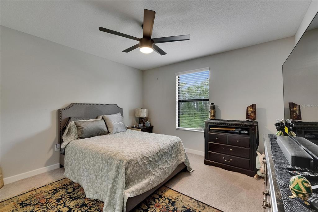 5057 Ivory Stone Drive Wimauma, FL 33598 - Photo 37 of 46 a bedroom with a bed and a ceiling fan