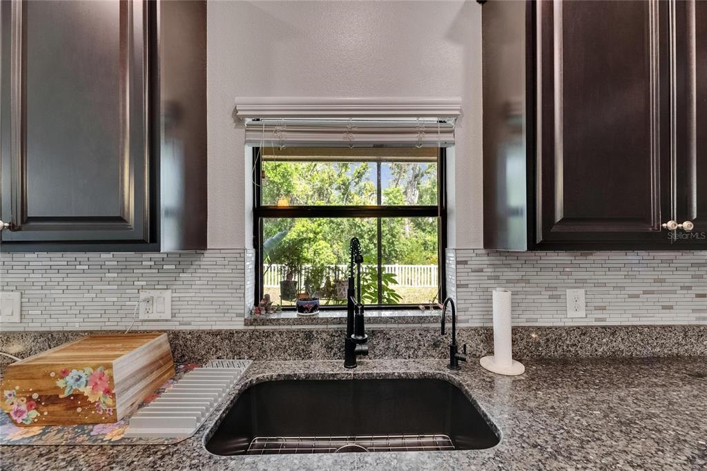 5057 Ivory Stone Drive Wimauma, FL 33598 - Photo 10 of 46 a kitchen with granite countertop a sink and a window