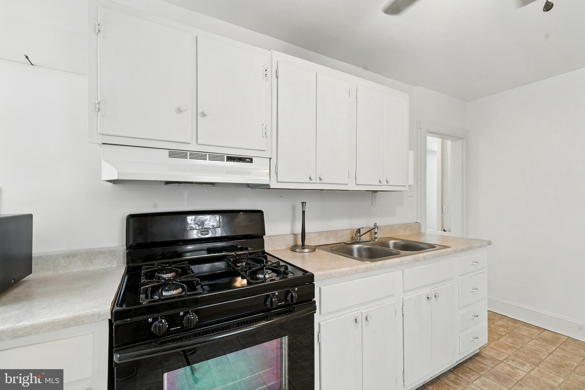 110 South Mill Street Chestertown, MD 21620 - Photo 21 of 39 a kitchen with white cabinets and black appliances