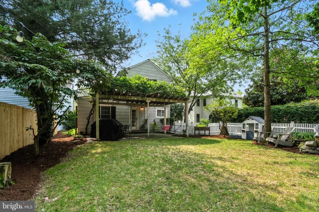 a view of a backyard with table and chairs and a large tree
