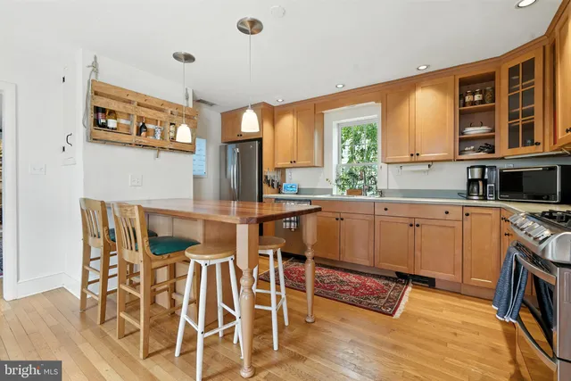 a kitchen with stainless steel appliances kitchen island granite countertop a stove a sink and a microwave