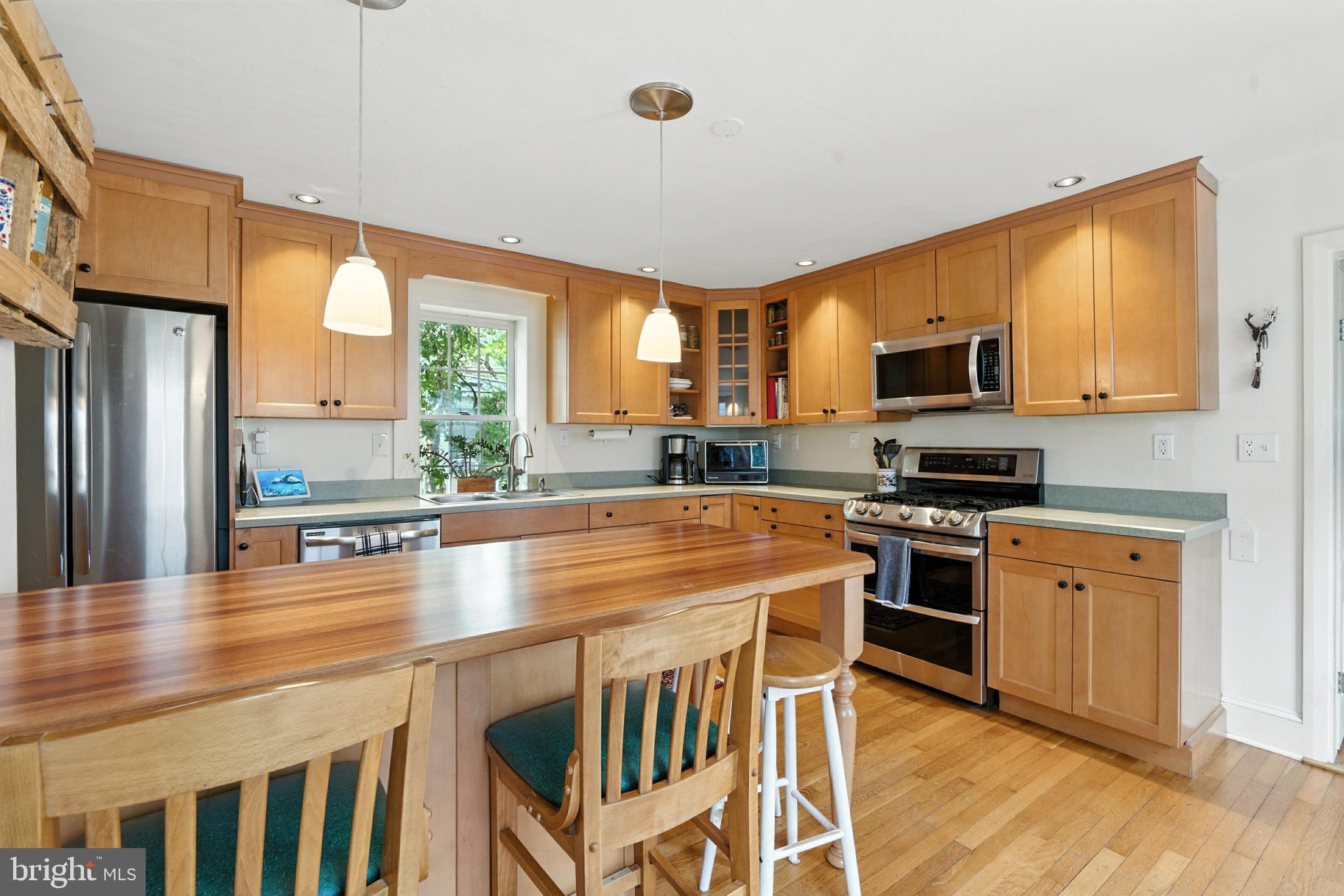 110 South Mill Street Chestertown, MD 21620 - Photo 9 of 39 a kitchen with stainless steel appliances granite countertop a stove top oven a sink dishwasher a dining table and chairs with wooden floor