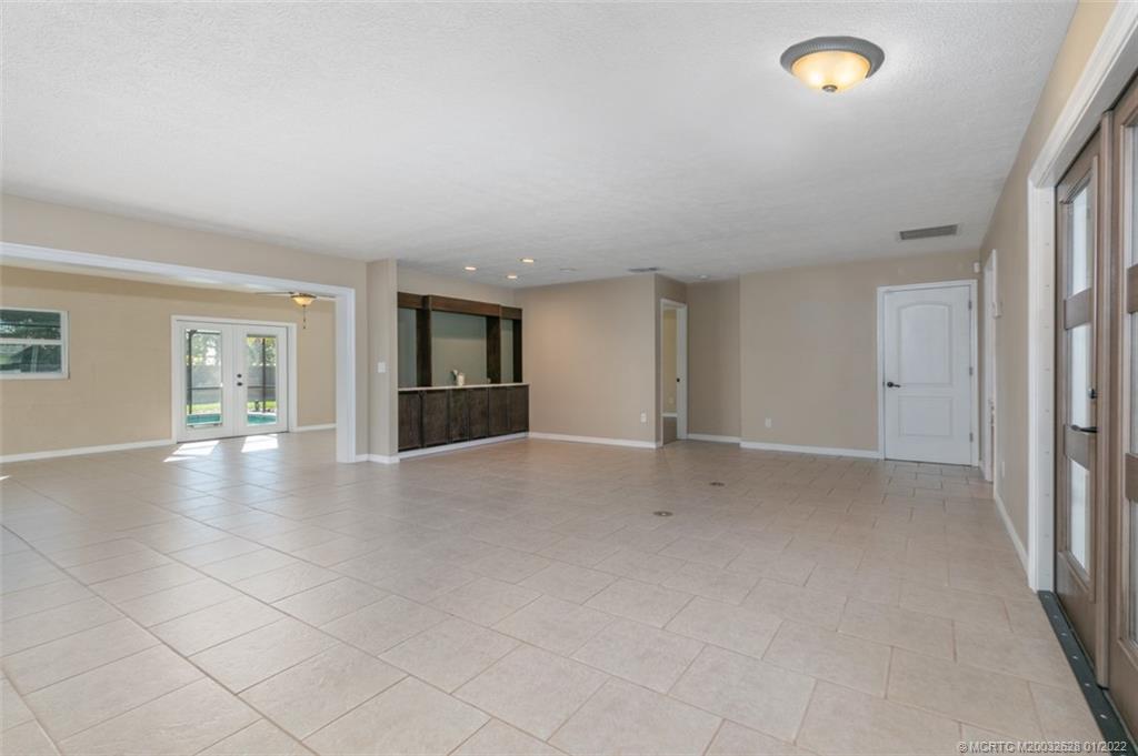 2891 Southeast Farley Road Port St. Lucie, FL 34952 - Photo 11 of 53 an empty room with windows and entrance to other room
