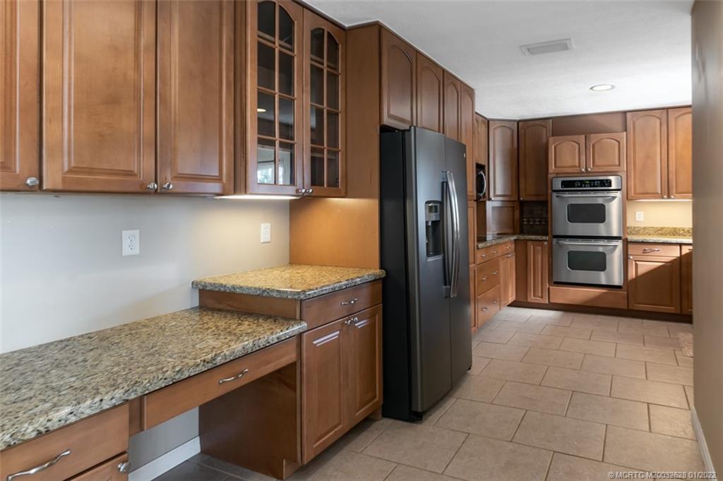 2891 Southeast Farley Road Port St. Lucie, FL 34952 - Photo 13 of 53 a kitchen with stainless steel appliances granite countertop a refrigerator and a sink