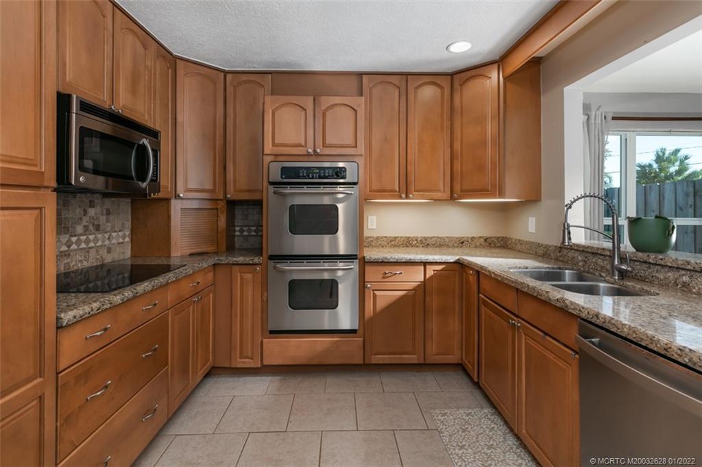 2891 Southeast Farley Road Port St. Lucie, FL 34952 - Photo 14 of 53 a kitchen with stainless steel appliances granite countertop a stove microwave and sink