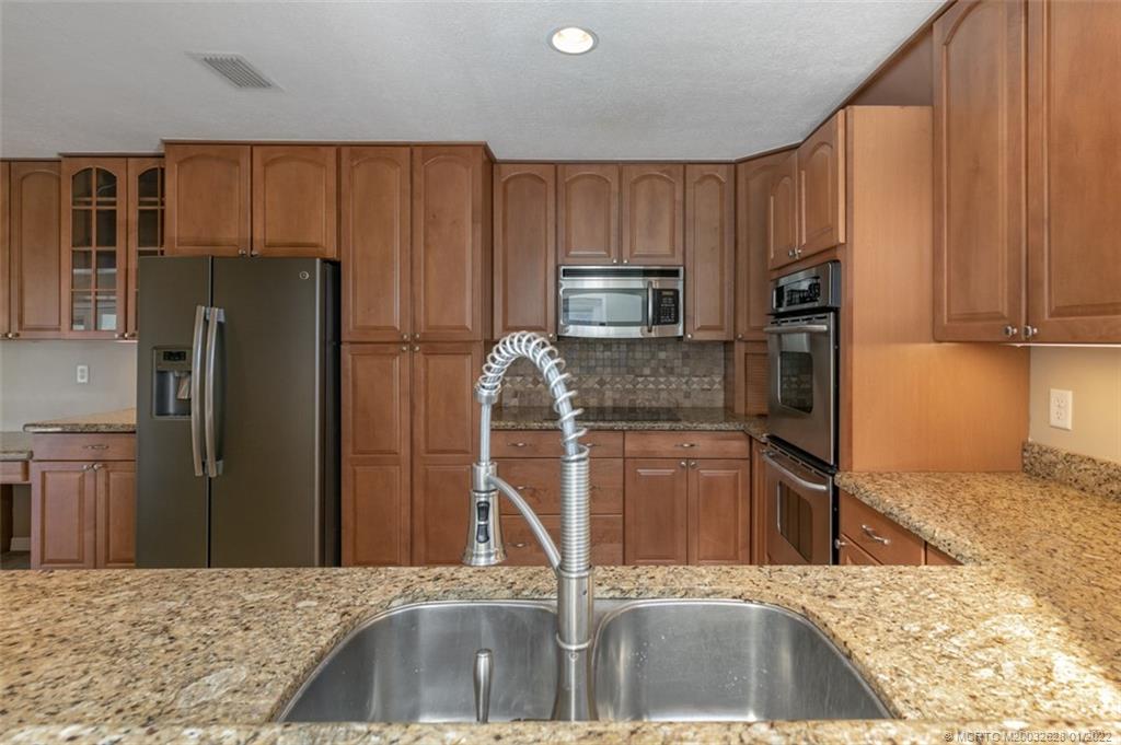 2891 Southeast Farley Road Port St. Lucie, FL 34952 - Photo 15 of 53 a kitchen with stainless steel appliances granite countertop a refrigerator and a sink