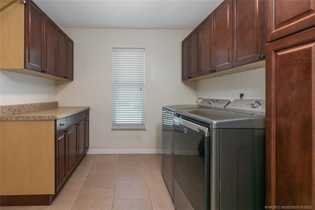 2891 Southeast Farley Road Port St. Lucie, FL 34952 - Photo 24 of 53 a utility room with cabinets washer and dryer